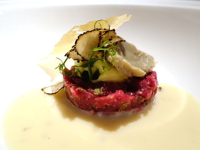Battuta di fassone, spuma all’olio d’oliva, crema al Parmigiano Reggiano e patate, carciofi confit, e tartufo Beef tartare, extra virgin olive oil foam, Parmigiano Reggiano sauce, confit artichokes, black truffle
